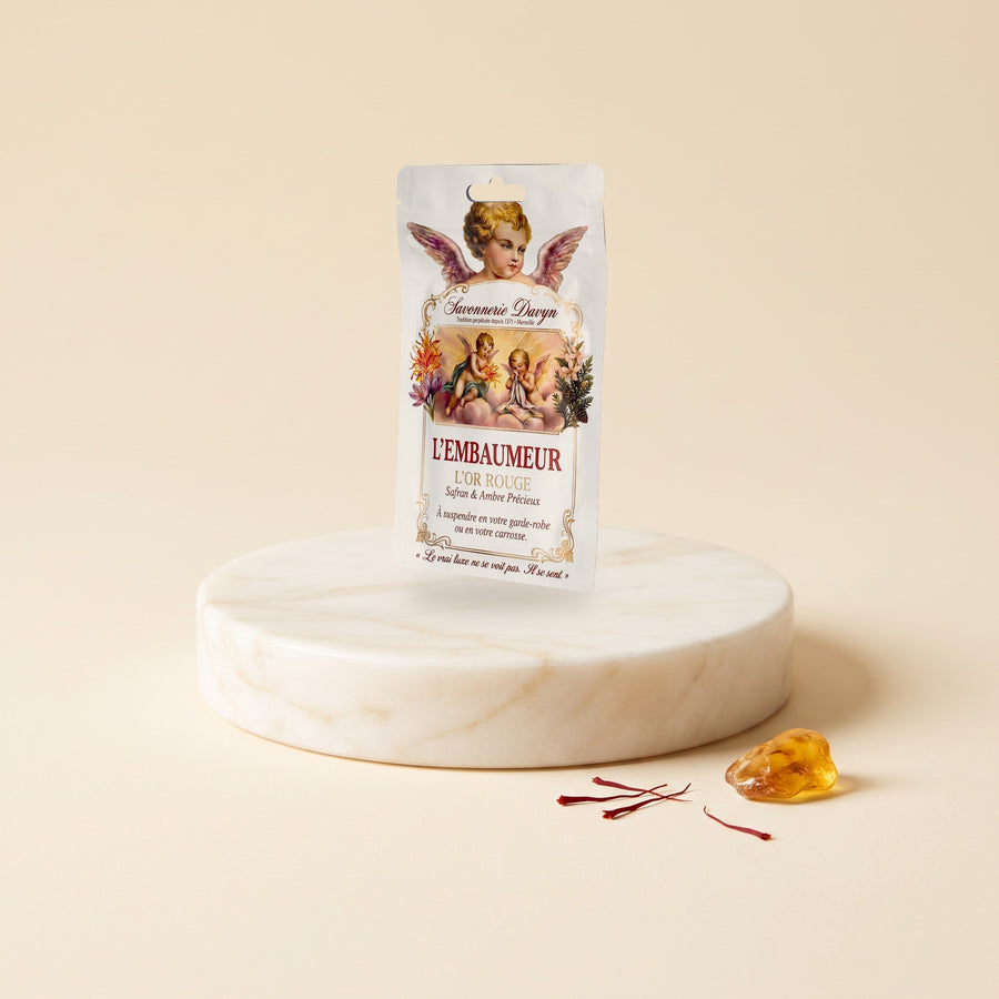 L’Embaumeur, sachet parfumé Safran & Ambre précieux, sur un socle de marbre